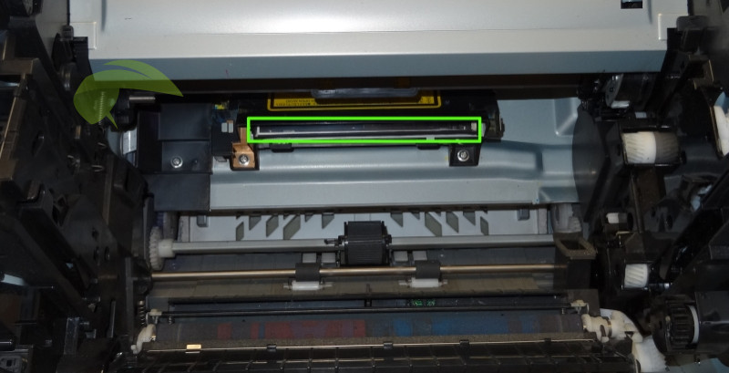 Krycie sklíčko lasera v tlačiarni Konica Minolta 1600W po vyčistení.